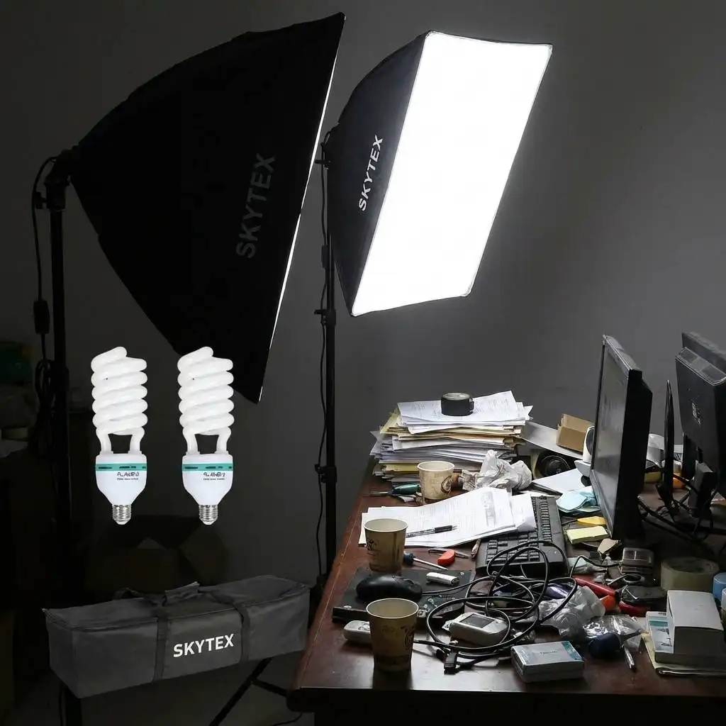 Harsh softbox light illuminating a cluttered desk in a dimly lit room to test brightness.